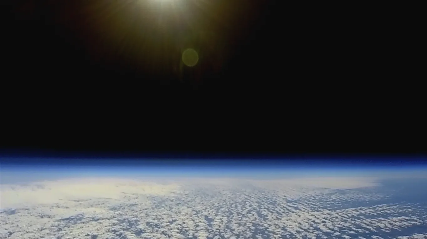 High-altitude balloon footage showing a flat horizon with the sun overhead.