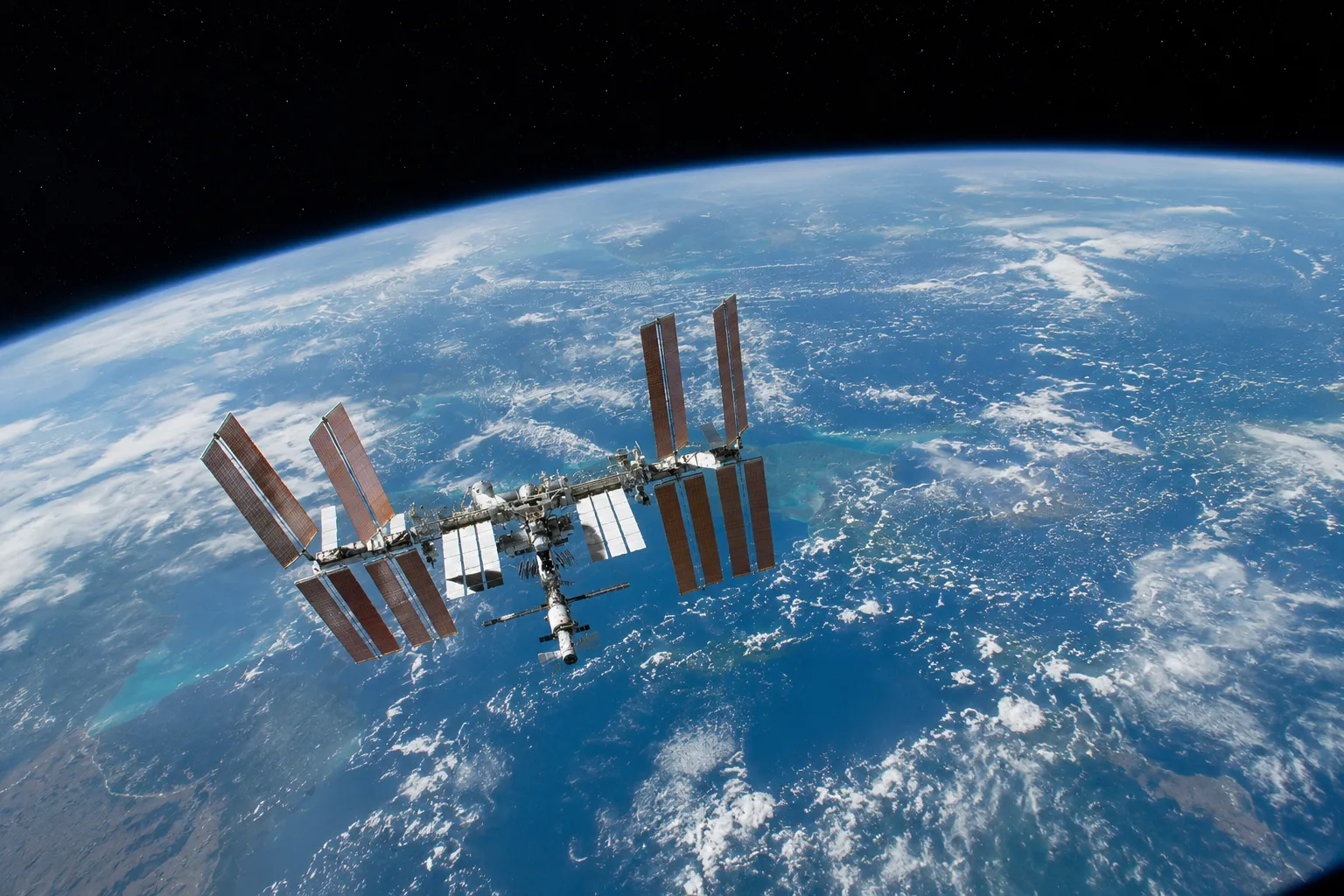 A rendering of an ISS-style space station above the earth.